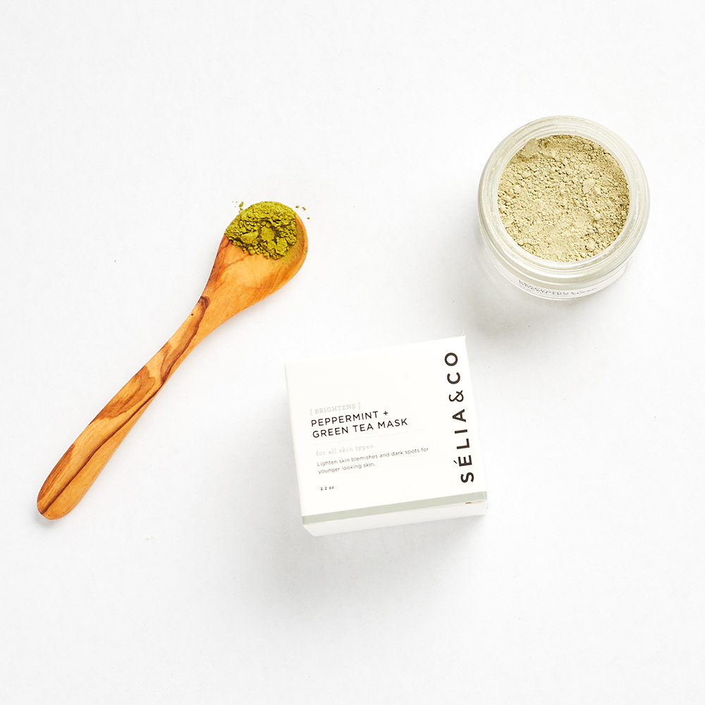 green tea clay mask on white background with wooden spoon